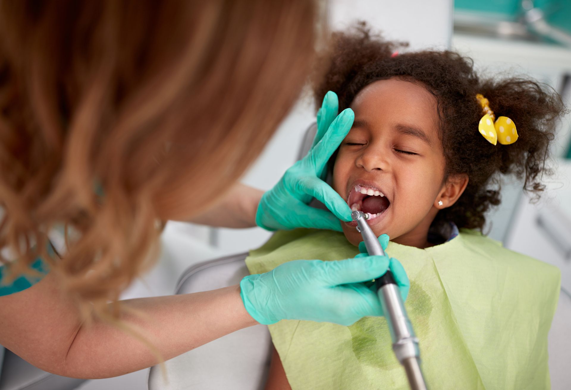 Image of a dentist working on a child