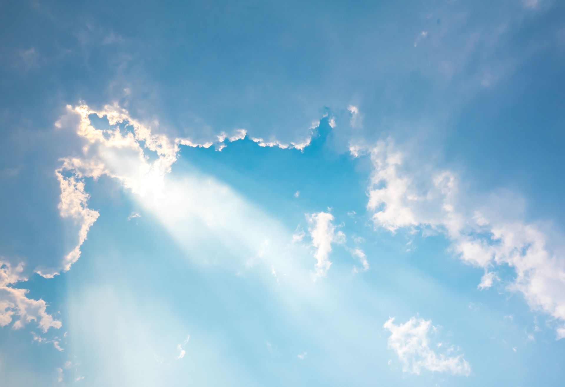 Image of light rays coming through clouds in the sky