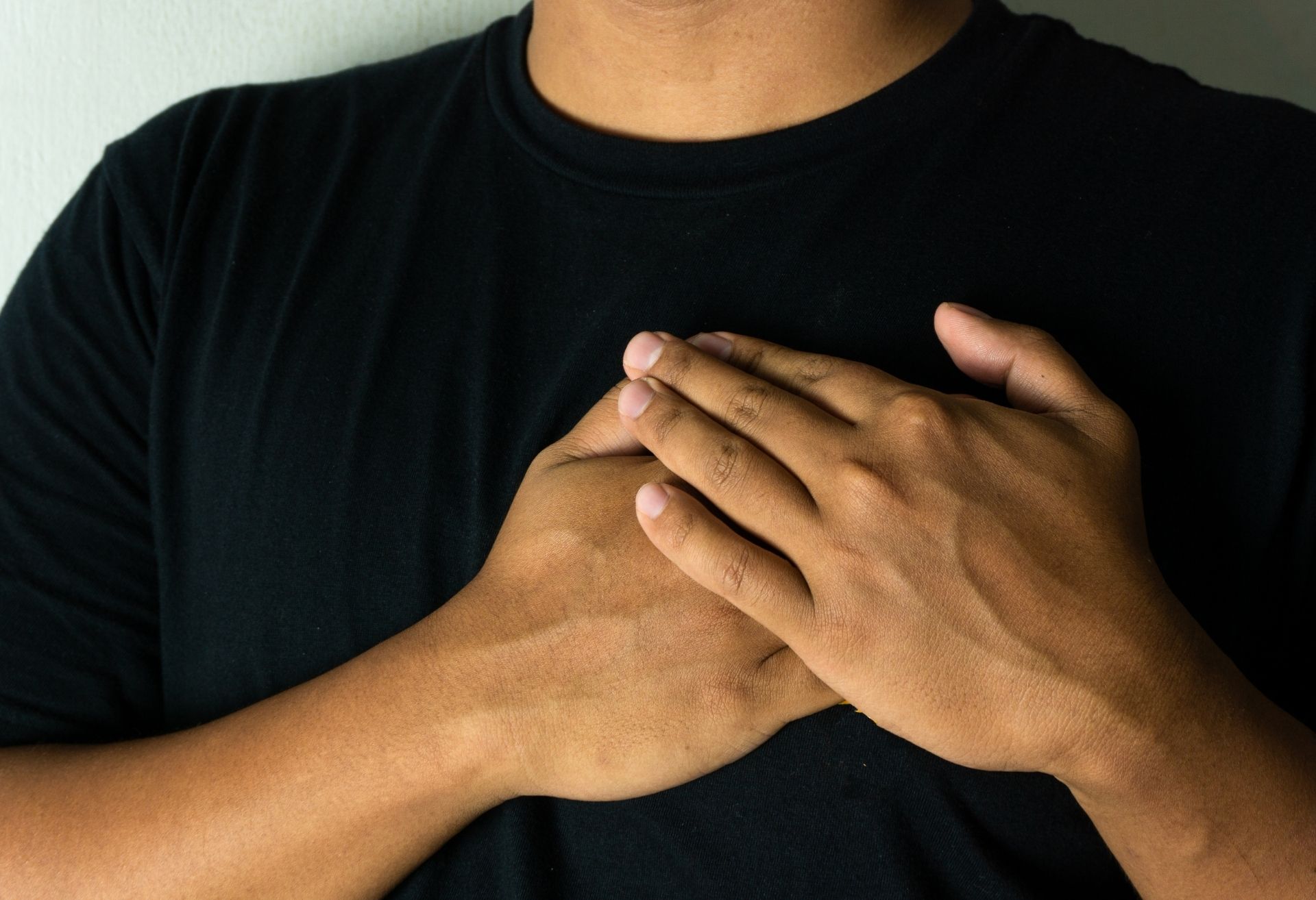 Image of man with hands held gently over his heart